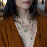 a flashy labradorite an gemstone is held on oxidized sterling silver dot chain with a second layer of cat's eye gemstones and fresh water pearl necklace