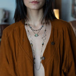 a flashy labradorite an gemstone is held on oxidized sterling silver dot chain with a second layer of cat's eye gemstones and fresh water pearl necklace