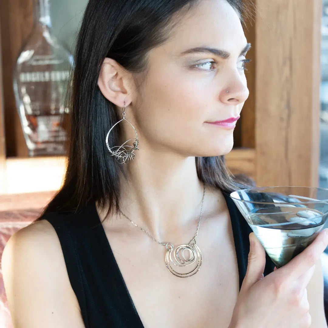 Handmade hammered and darkened sterling silver knot surrounded by hammered bronze large arches on a sterling silver tube chain necklace