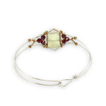 Sterling silver cuff bracelet with faceted serpentine jade rectangle at the center surrounded by faceted garnet gemstones and brass hammered wire