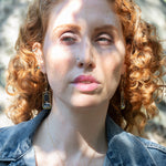 Smooth kyanite gemstones are accented with crystal cubes and blue tourmaline gemstones inside a brass rectangle earrings