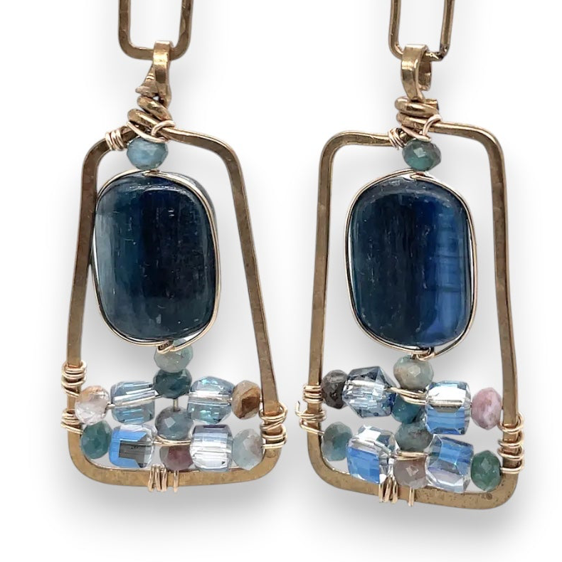 Smooth kyanite gemstones are accented with crystal cubes and blue tourmaline gemstones inside a brass rectangle earrings