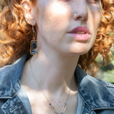 Smooth kyanite gemstones are accented with crystal cubes and blue tourmaline gemstones inside a brass rectangle earrings