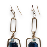Smooth kyanite gemstones are accented with crystal cubes and blue tourmaline gemstones inside a brass rectangle earrings