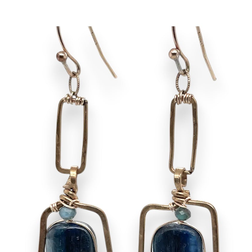 Smooth kyanite gemstones are accented with crystal cubes and blue tourmaline gemstones inside a brass rectangle earrings