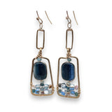 Smooth kyanite gemstones are accented with crystal cubes and blue tourmaline gemstones inside a brass rectangle earrings