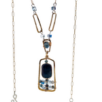 Smooth kyanite accented with crystal cubes and blue tourmaline gemstones inside a brass rectangle hanging from handmade hammered brass rectangle link necklace