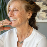 Brass crescent necklace on oxidized sterling silver tube chain with blue kyanite slice, mauve moonstone drop, crystal, iolite, and tourmalinated quartz gemstones on sterling silver wire necklace