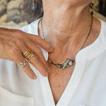 Brass crescent necklace on oxidized sterling silver tube chain with blue kyanite slice, mauve moonstone drop, crystal, iolite, and tourmalinated quartz gemstones on sterling silver wire necklace