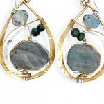 A pair of faceted labradorite earrings with emerald gemstones, set in layers of hammered sterling silver and brass leaf earrings, with sterling silver french hooks.
