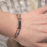 A stackable Labradorite and moonstone gemstone sterling silver skinny bracelet with twisted sterling silver and hammered bronze details