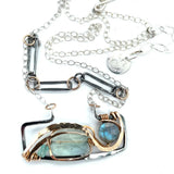 A double-layered necklace with a geometric design, featuring a rectangular darkened sterling silver pendant with a fluorite gemstone, flashy labradorite gemstone, and bronze accents, connected to chain links and additional bronze rings.