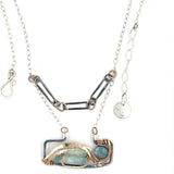 A double-layered necklace with a geometric design, featuring a rectangular darkened sterling silver pendant with a fluorite gemstone, flashy labradorite gemstone, and bronze accents, connected to chain links and additional bronze rings.
