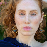 A pair of brass drop earrings featuring faceted lapis and sodalite gemstones and a crystal coin design, attached with gold filled and brass twist wires