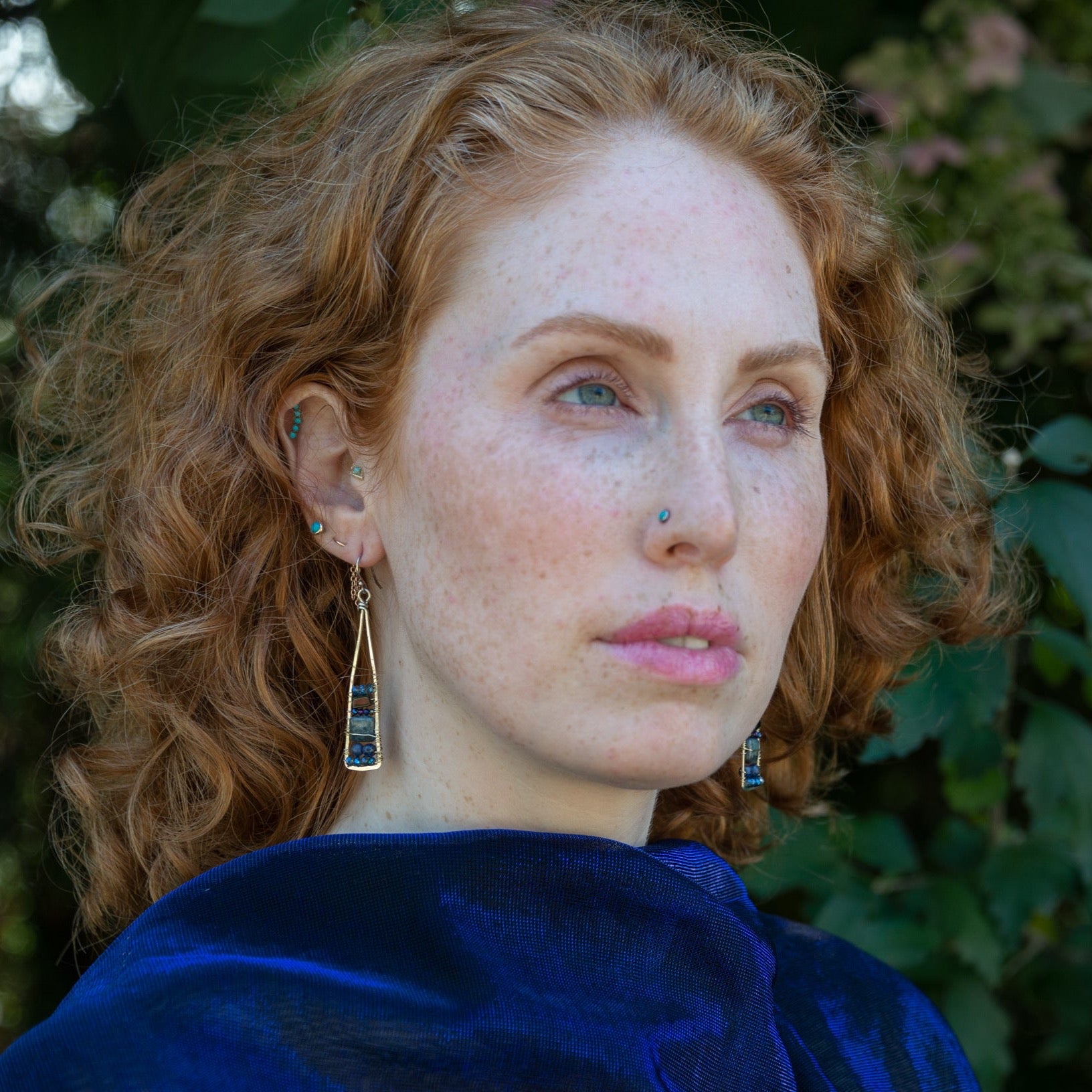 Lapis and onyx gemstones stacked with blue crystal on gold filled wire within a skinny, tall sterling silver triangle shaped earrings