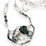 kambaba jasper, fresh water pearl. pyrite, and green kyanite gemstones are laid within layers of sterling silver and gold filled wire on a darkened sterling silver pendant necklace