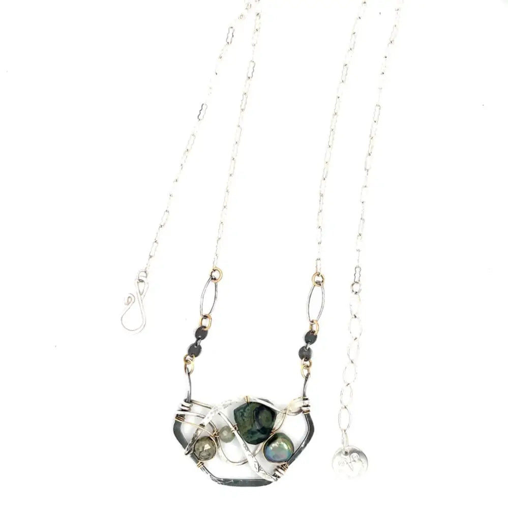 kambaba jasper, fresh water pearl. pyrite, and green kyanite gemstones are laid within layers of sterling silver and gold filled wire on a darkened sterling silver pendant necklace