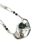 kambaba jasper, fresh water pearl. pyrite, and green kyanite gemstones are laid within layers of sterling silver and gold filled wire on a darkened sterling silver pendant necklace