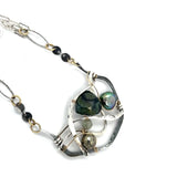 kambaba jasper, fresh water pearl. pyrite, and green kyanite gemstones are laid within layers of sterling silver and gold filled wire on a darkened sterling silver pendant necklace