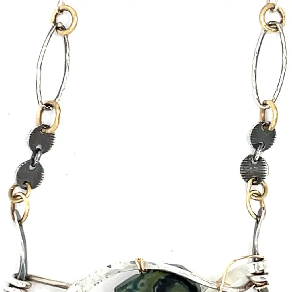 kambaba jasper, fresh water pearl. pyrite, and green kyanite gemstones are laid within layers of sterling silver and gold filled wire on a darkened sterling silver pendant necklace