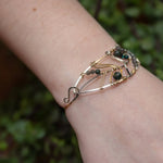 Bloodstone and labradorite faceted gemstones held within a sterling silver hand formed wave bracelet with oxidized sterling twist, gold filled wire and brass accents