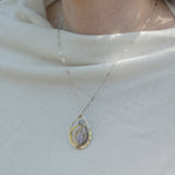 Teardrop-shaped sterling silver and brass pendatn with amethyst, labradorite, and crystal gemstones on delicate sterling silver chain
