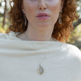 Teardrop-shaped sterling silver and brass pendatn with amethyst, labradorite, and crystal gemstones on delicate sterling silver chain