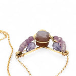 A gold-filled necklace with a bronze point pendant featuring a mauve moonstone faceted cube gemstone and petals of ombre faceted amethyst mini cube gemstones.