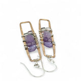A pair of skinny tall bronze rectangle earrings with lilac purple amethyst pebbles, faceted amethyst gemstones, cubic zirconia purple drops, and crystal cubes stacked ontop of each other
