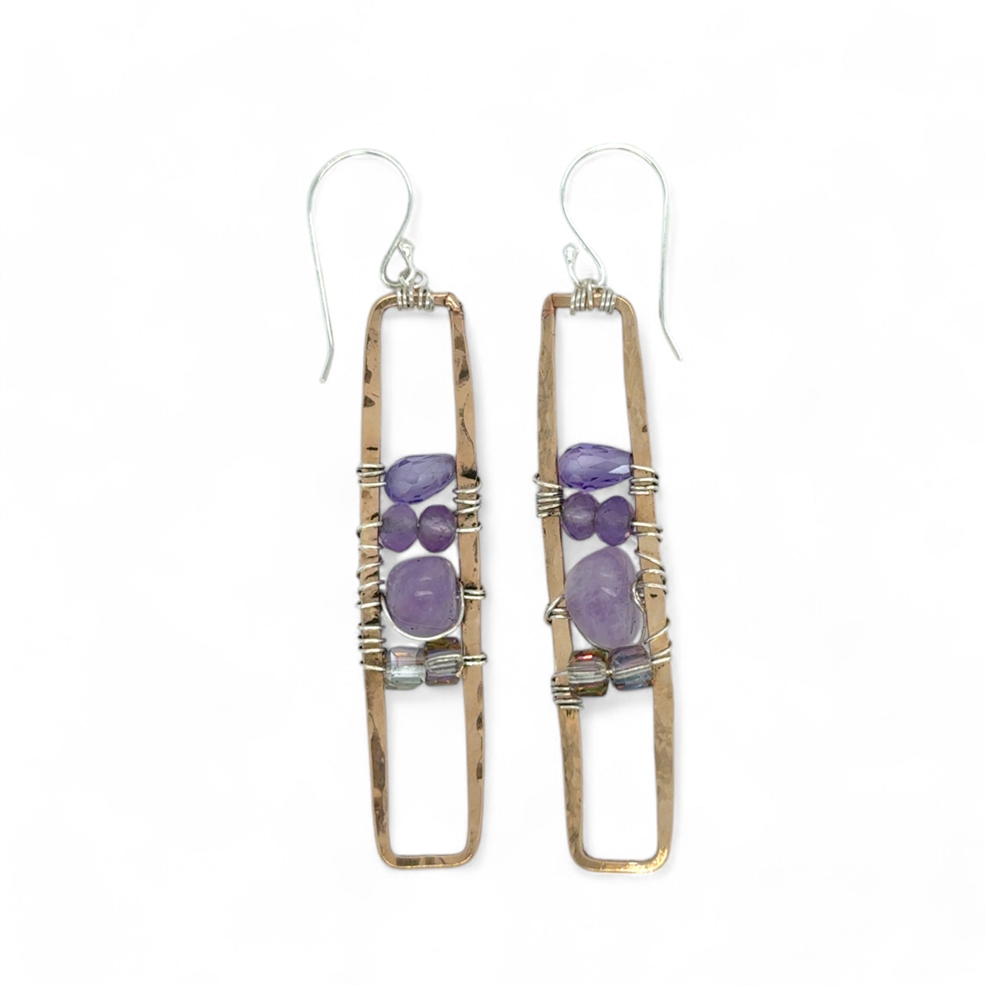 A pair of skinny tall bronze rectangle earrings with lilac purple amethyst pebbles, faceted amethyst gemstones, cubic zirconia purple drops, and crystal cubes stacked ontop of each other