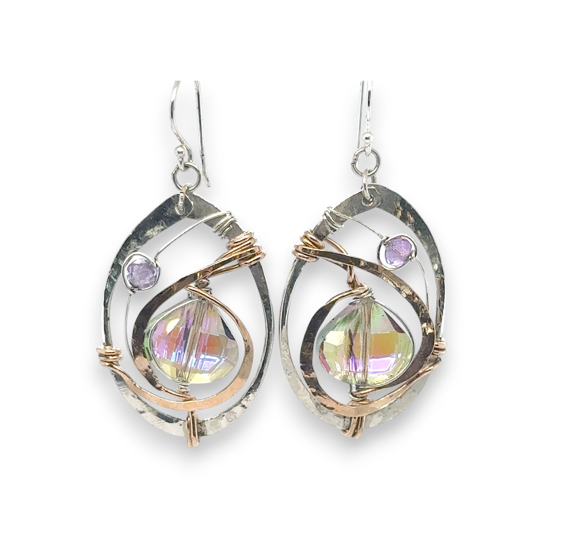 Hammered sterling silver oval earrings with hammered bronze accents holding and iridescent lilac crystal drop and amethyst gemstones