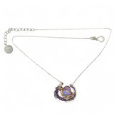 A lilac color iridescent crystal in a sterling silver channel pendant necklace with hammered bronze detailing, encrusted with faceted amethyst gemstones, on an adjustable sterling silver chain.