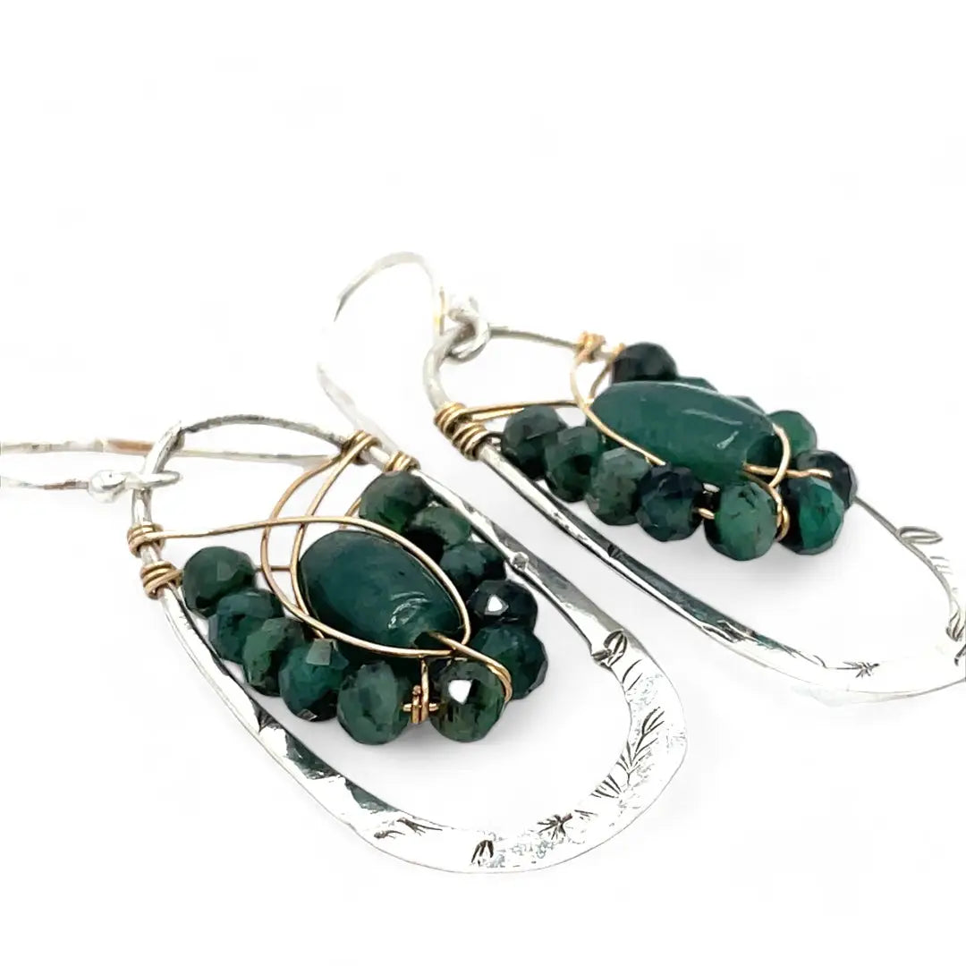 A pair of sterling silver hoop leaf stamped earrings with gold-filled woven bands, jade, and faceted emerald gemstones.