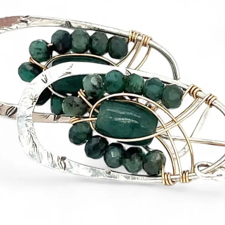 A pair of sterling silver hoop leaf stamped earrings with gold-filled woven bands, jade, and faceted emerald gemstones.