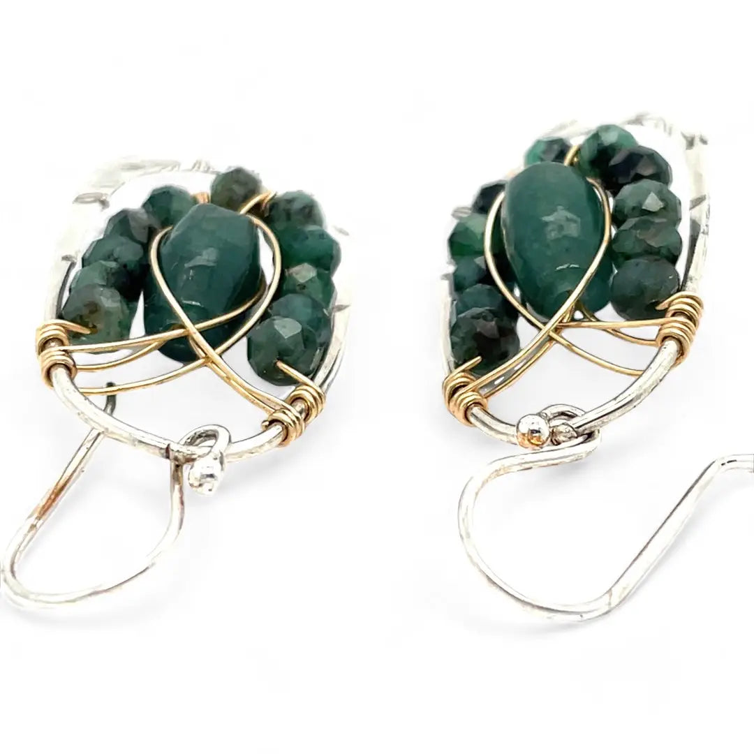 A pair of sterling silver hoop leaf stamped earrings with gold-filled woven bands, jade, and faceted emerald gemstones.
