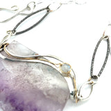Raw edge amethyst slab held in waves of sterling silver and gold fill wires with a moonstone accent on delicate sterling silver chain with oxidized sparkly diamond cut link necklace