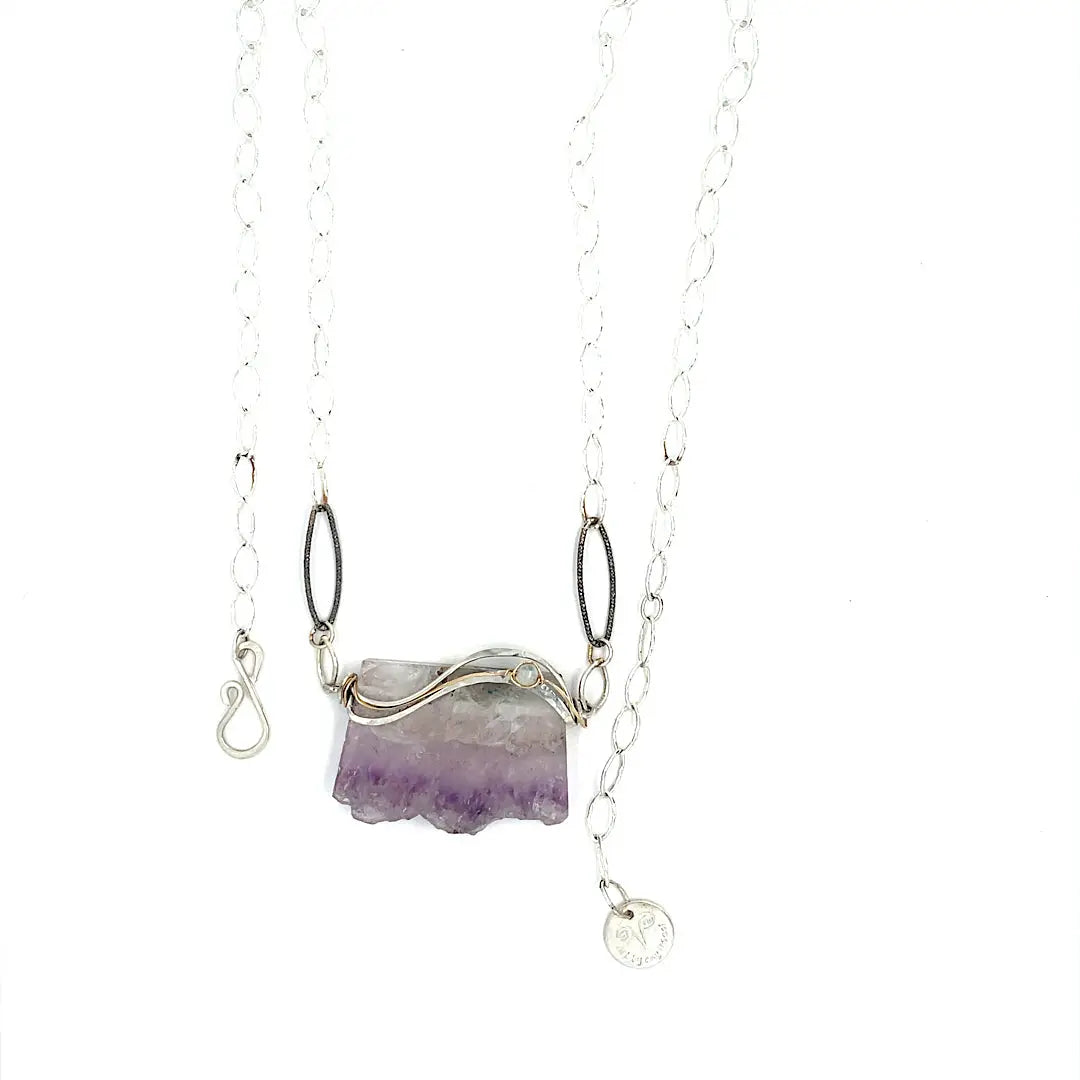 Raw edge amethyst slab held in waves of sterling silver and gold fill wires with a moonstone accent on delicate sterling silver chain with oxidized sparkly diamond cut link necklace