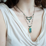 Turquoise rectangle wrapped in layers of hammered bronze and sterling silver wire pendant with another layer with chrysocolla and labradorite drop gemstones on oxidized sterling silver links and chain