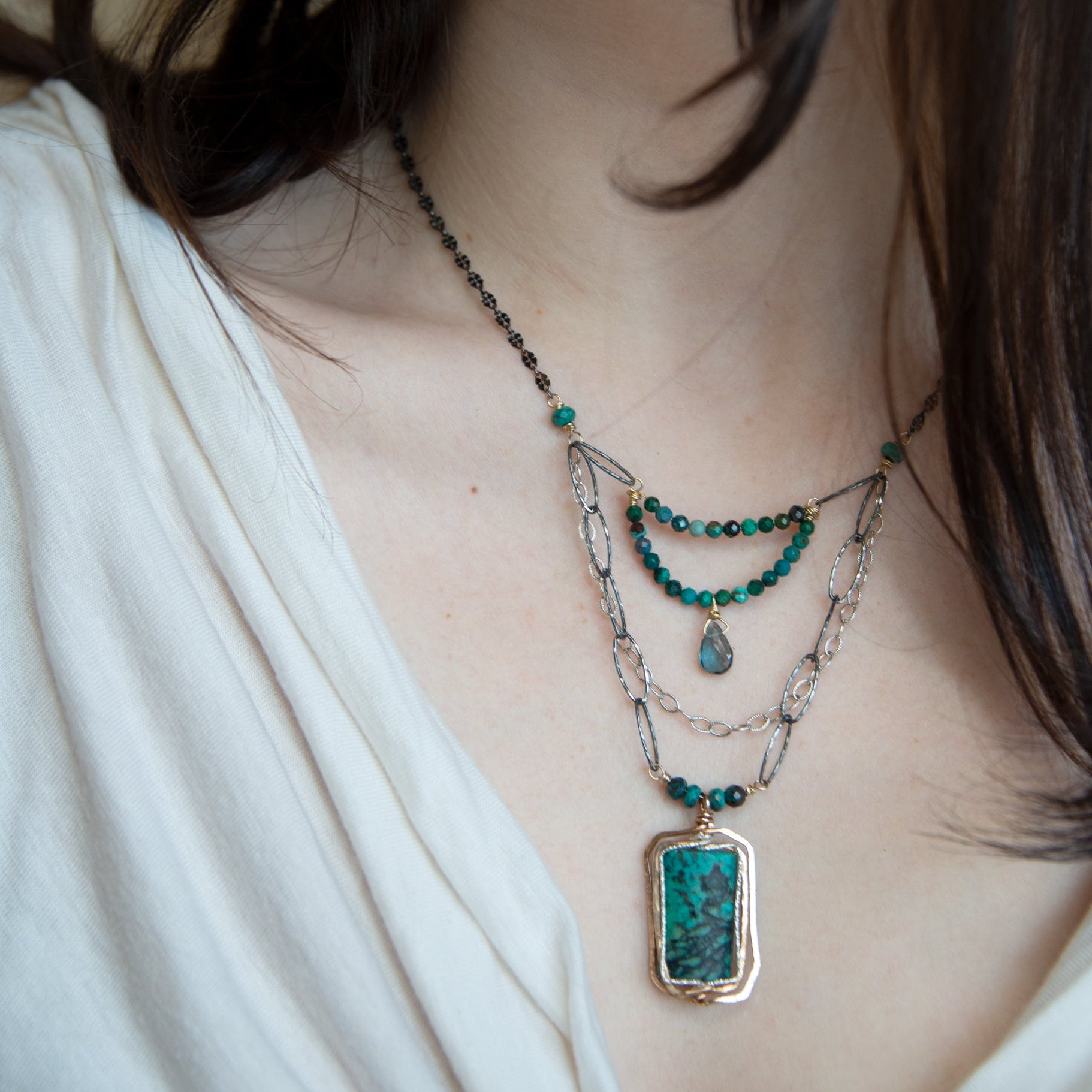 Turquoise rectangle wrapped in layers of hammered bronze and sterling silver wire pendant with another layer with chrysocolla and labradorite drop gemstones on oxidized sterling silver links and chain