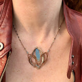 Lotus flower shaped bronze necklace with a large blue chalcedony gemstone point with blue quartz, labradorite, apatite, and sterling silver accents on delicate sterling silver chain