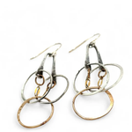 a pair of oxidized fern stamped arch earrings with sterling silver and bronze interlocked rings
