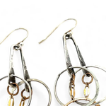 a pair of oxidized fern stamped arch earrings with sterling silver and bronze interlocked rings