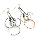 a pair of oxidized fern stamped arch earrings with sterling silver and bronze interlocked rings