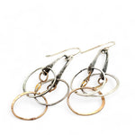 a pair of oxidized fern stamped arch earrings with sterling silver and bronze interlocked rings