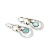 Mint fresh water pearl coin held within a stamped and hammered sterling silver open hoop hanging on a gold filled braided link