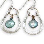 Mint fresh water pearl coin held within a stamped and hammered sterling silver open hoop hanging on a gold filled braided link