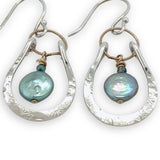 Mint fresh water pearl coin held within a stamped and hammered sterling silver open hoop hanging on a gold filled braided link