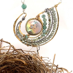 Mint fresh water pearl coin held within a brass pendant necklace filled with amazonite and crystal gemstones along side with oxidized sterling silver twist wire