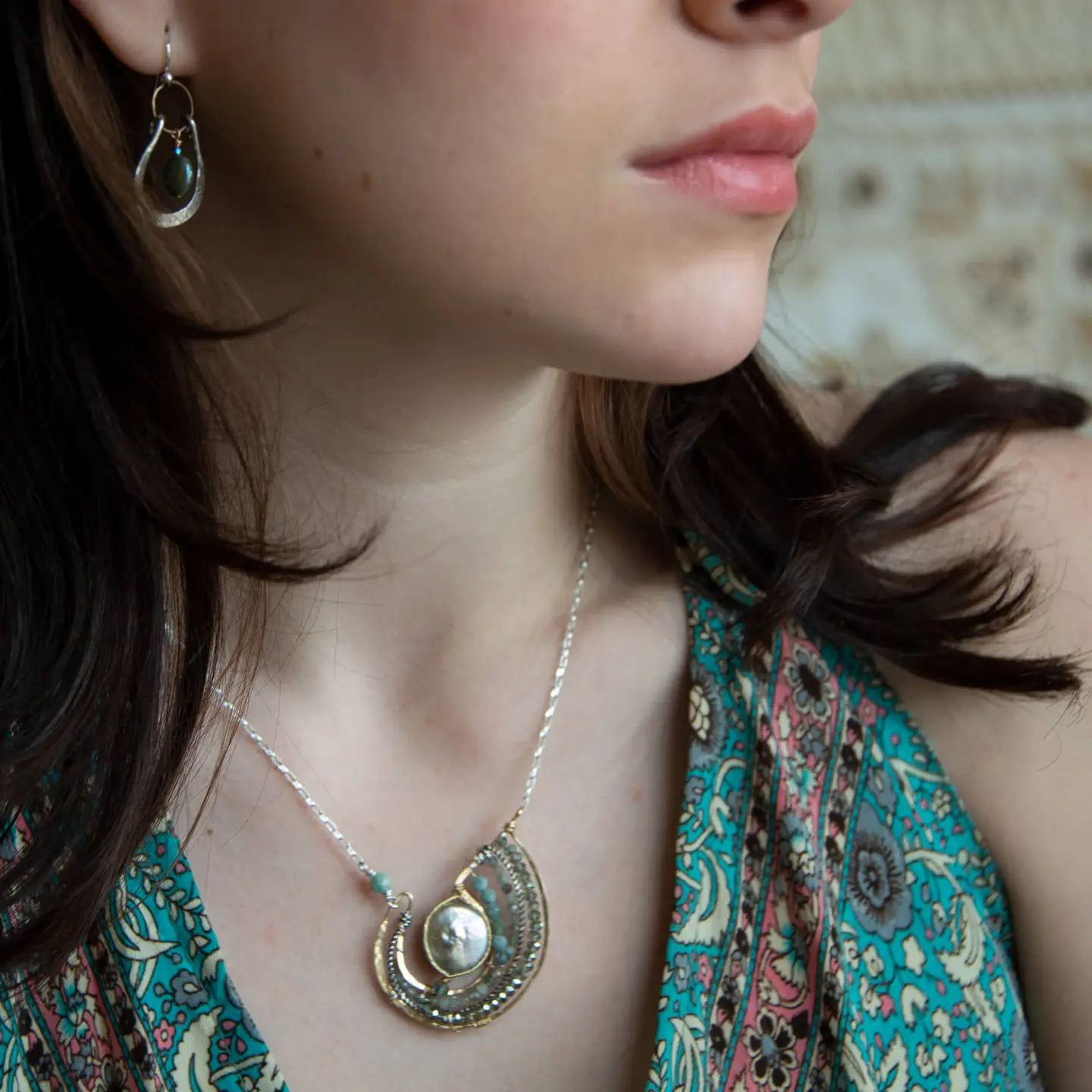 Mint fresh water pearl coin held within a brass pendant necklace filled with amazonite and crystal gemstones along side with oxidized sterling silver twist wire