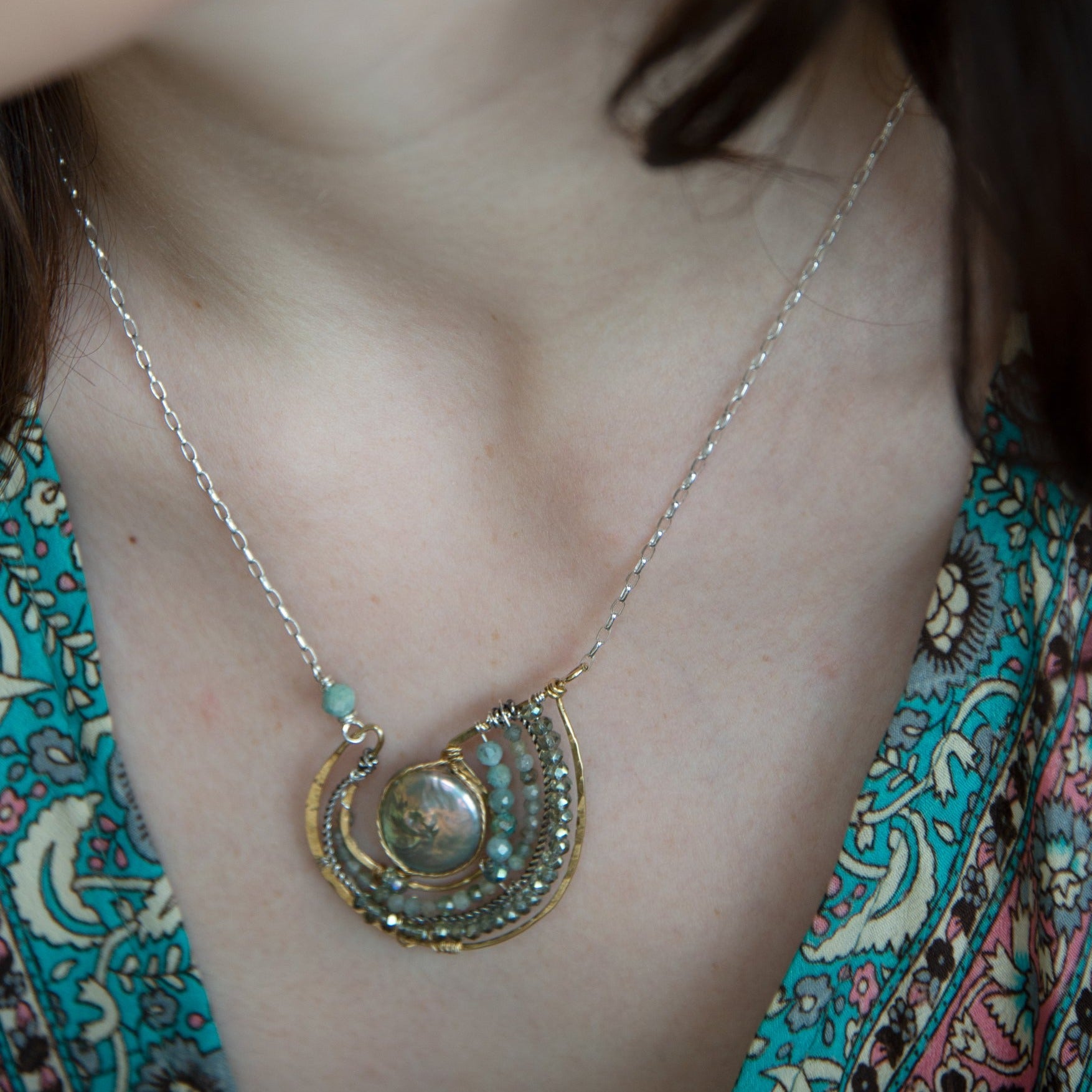 Mint fresh water pearl coin held within a brass pendant necklace filled with amazonite and crystal gemstones along side with oxidized sterling silver twist wire